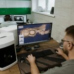 unrecognizable man working on computer in dental clinic